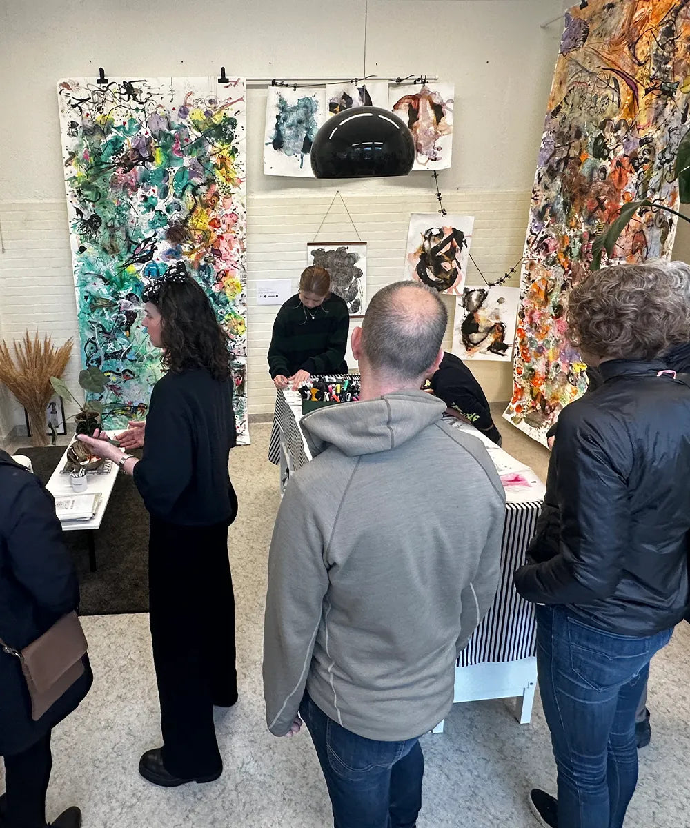 konstutställning i remoair studio med stora konstverk på väggarna och mycket besökare