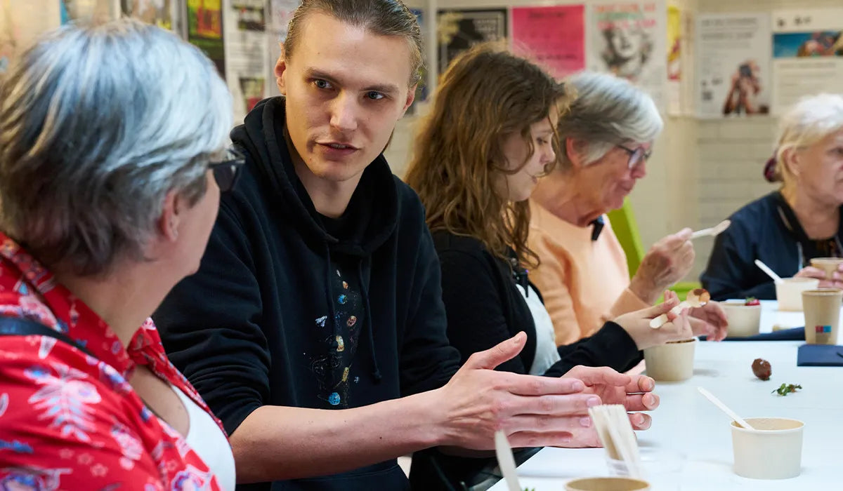 ungdomar och seniorer som diskuterar i kreativ samskapande miljö