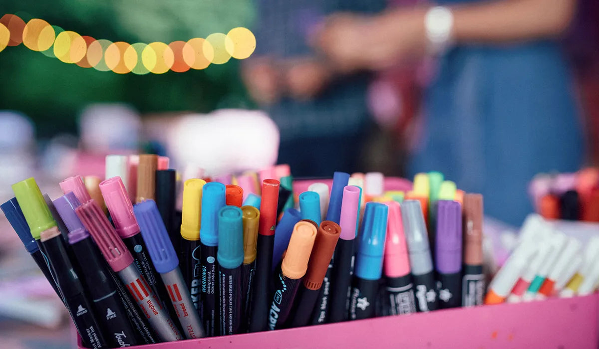 färgglada tuschpennor i en rosa ask