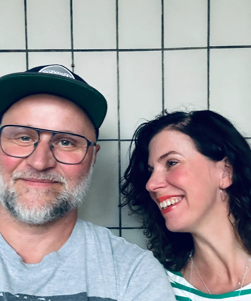 en man med keps och glasögon med en kvinna som skrattar bredvid