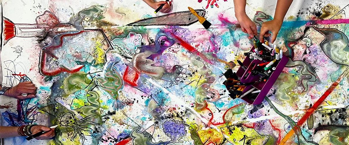 ett stort konstverk med flera personer vars händer syns när de målar